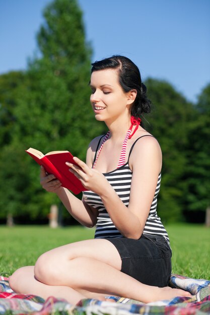 Woman reading book on meadow