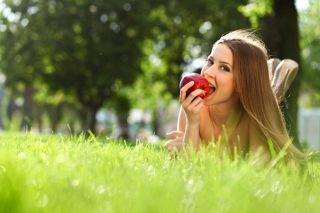 Woman reading book in the park on the grass