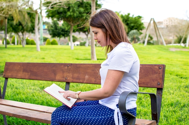 Woman reading a book in the park. left copyspace