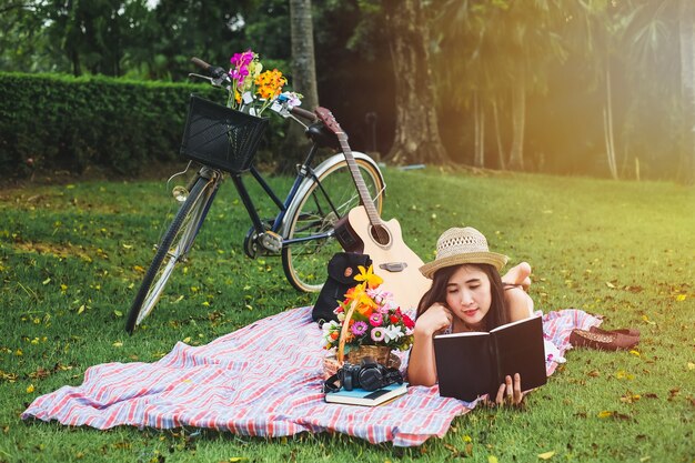 Donna che legge un libro sul relax del tempo. signora asiatica ha picnic