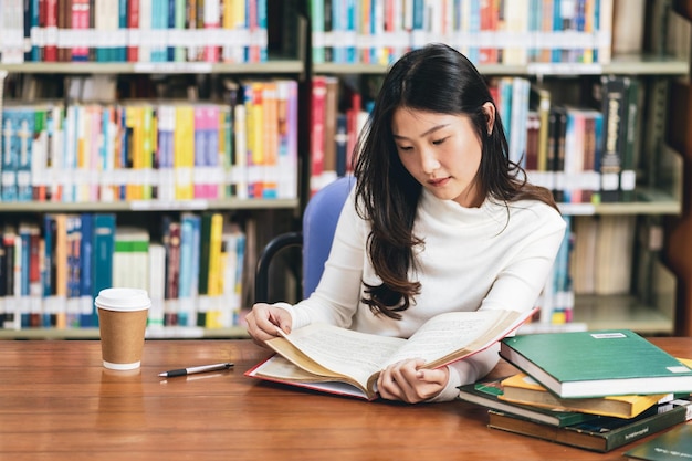 図書館のテーブルで本を読んでいる女性