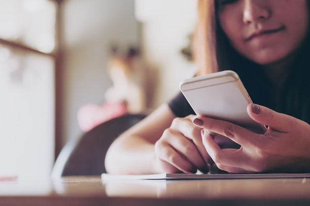 Woman reading a book and using smart phone