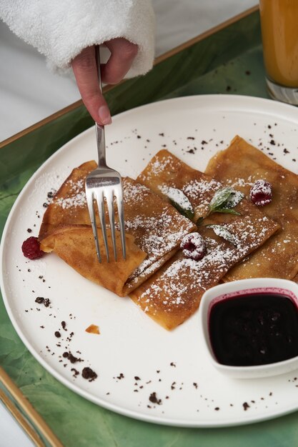 Woman reading book while having breakfast in bed. Woman in bathrobe having breakfast in hotel bed, close-up