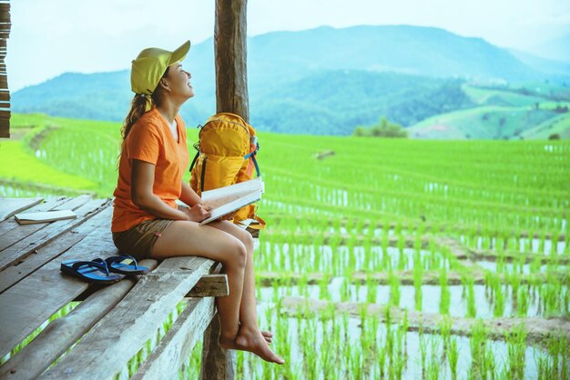 Photo woman reading book while sitting at agricultural field