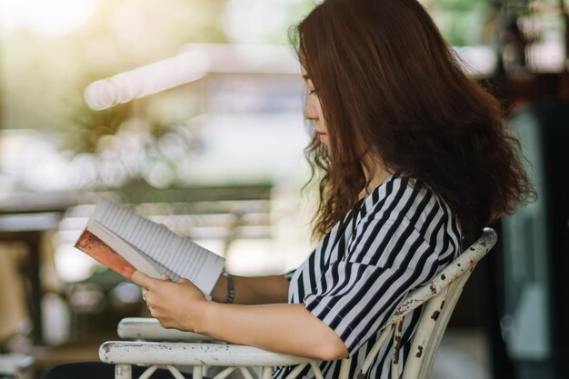 写真 家に座って本を読んでいる女性