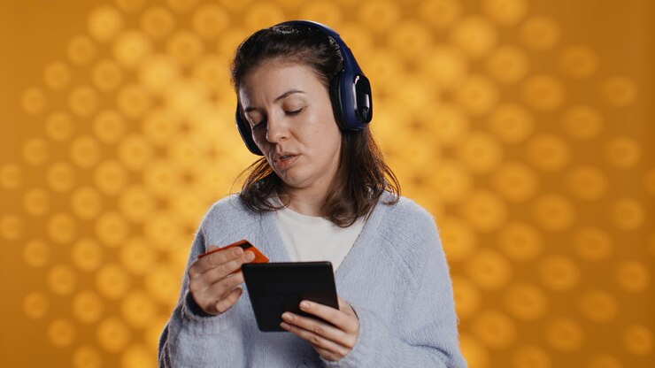 Photo woman reading ebook listening music purchasing books studio background
