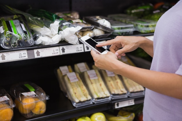 Woman reading her shopping list on smartphone