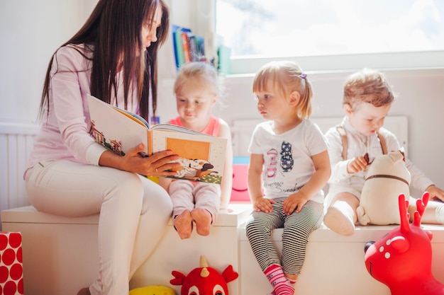 Photo woman reading to kids in school