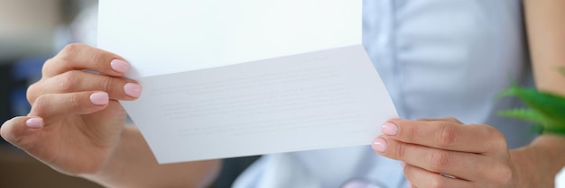 Photo woman reading letter while sitting at table with open envelope businesswoman working with