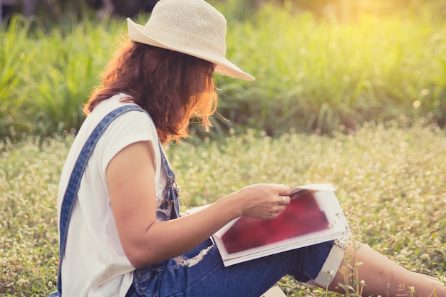 女性の庭で雑誌を読む