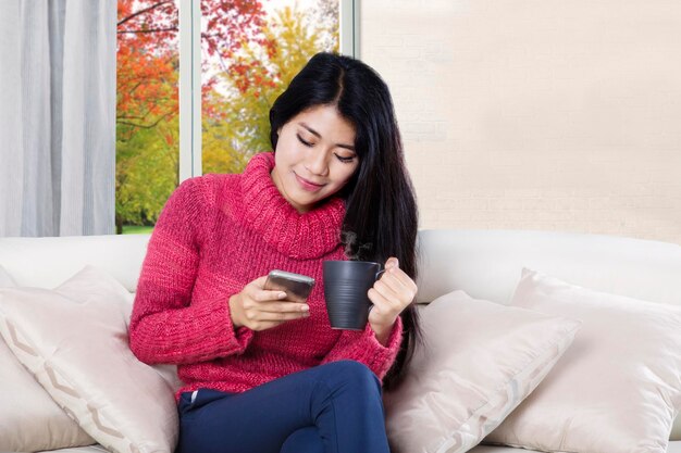 Woman reading messages on a smartphone at home