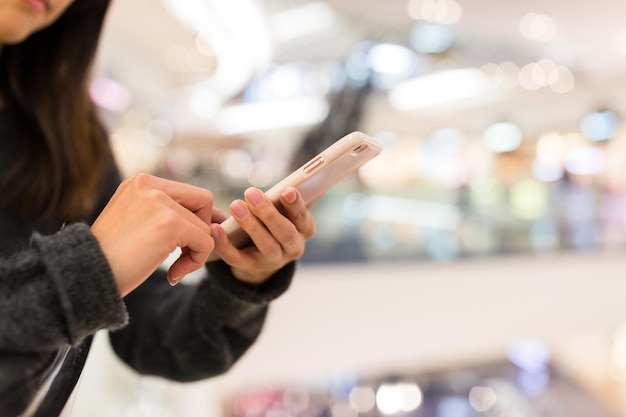 携帯電話で本を読む女性