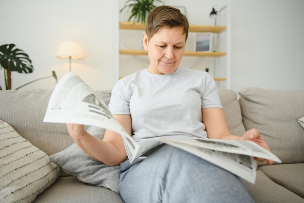 Woman reading newspaper at home