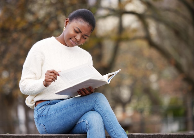 Photo woman reading and notebook in the outdoor at university for knowledge and research at school female student book and learning at the park for an education with a scholarship for motivation