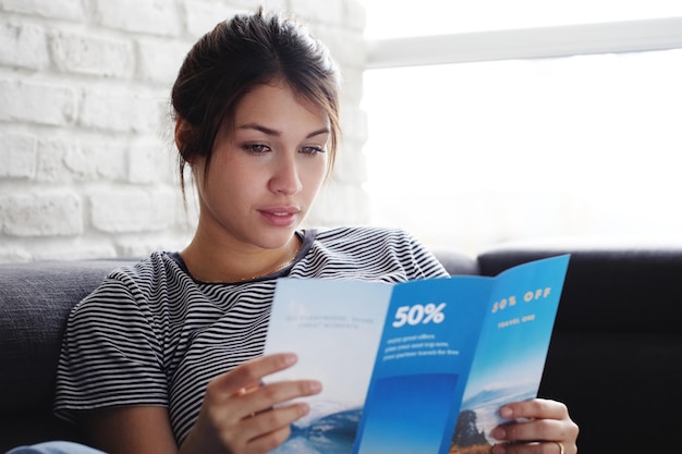 Photo woman reading pamphlet while sitting at home