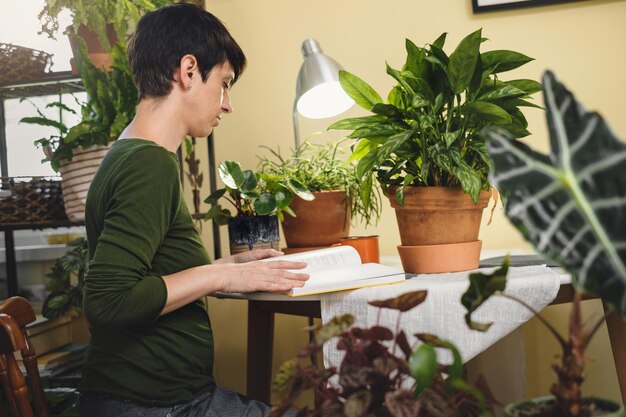 Photo woman at reading place near houseplants with opened book digital detox