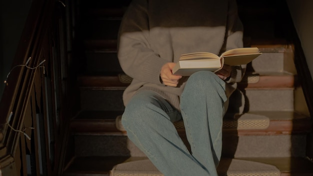 Woman reading sitting on stairs in sunlight