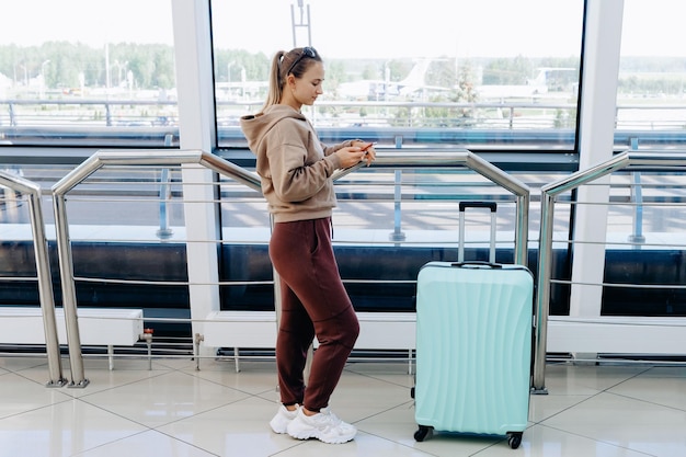 Woman reading an sms while standing at the airport