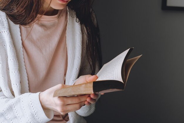 女性は昼間、家の窓際で本を読みます。