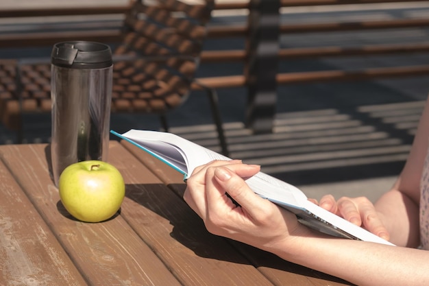 Woman reads a book near the office during a work break