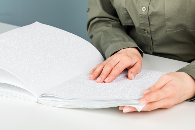 A woman reads a book written in Braille