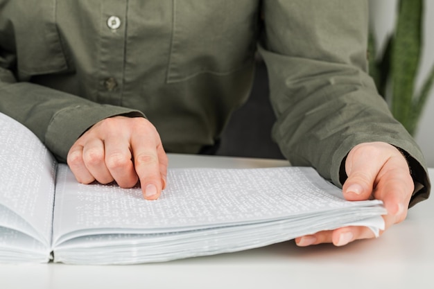 A woman reads a book written in Braille