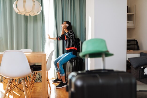 Woman ready for travel, calling for taxi