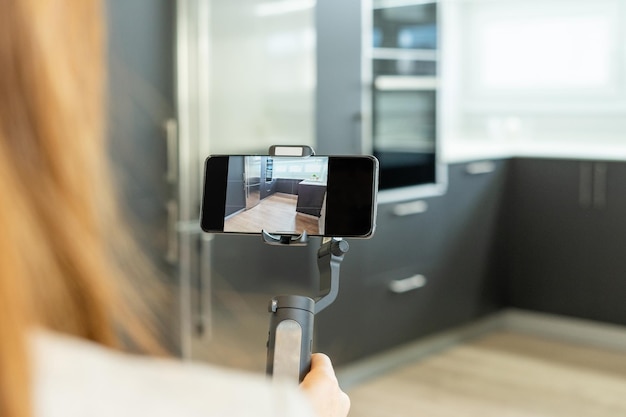 Photo woman real estate agent makes a video showing the kitchen of a property to all her clients