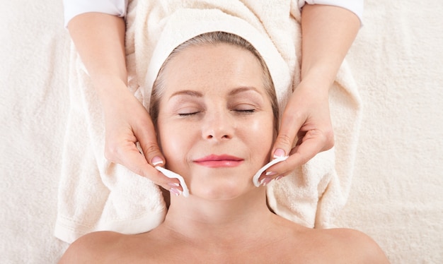 Woman receives a facial treatment in a spa salon