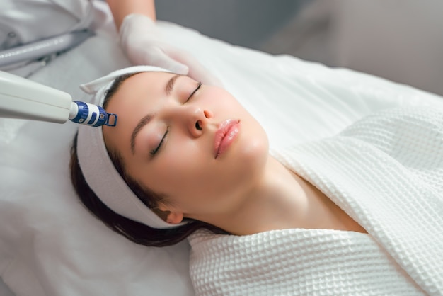 A woman receives laser treatment of the face in a cosmetology clinic a concept of skin rejuvenation