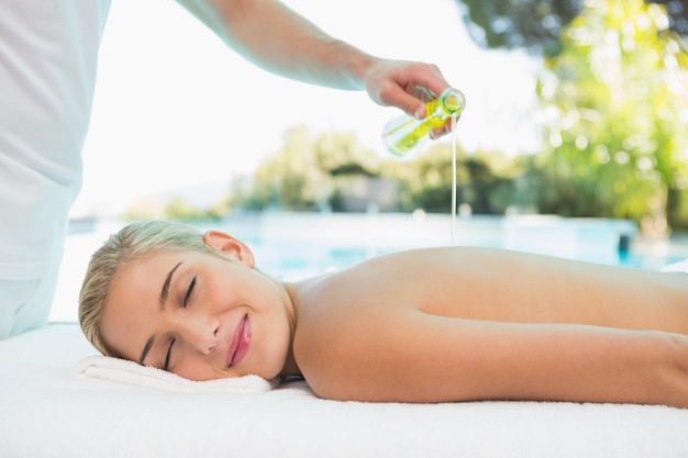 Woman receiving back massage at spa center