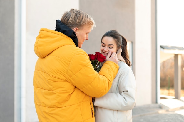 야외에서 발렌타인 데이에 남자 친구로부터 빨간 장미 꽃다발을받는 여자