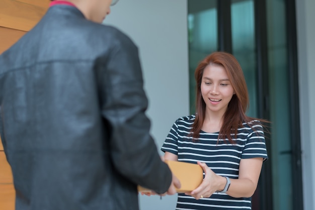 Woman receiving a box from delivery man