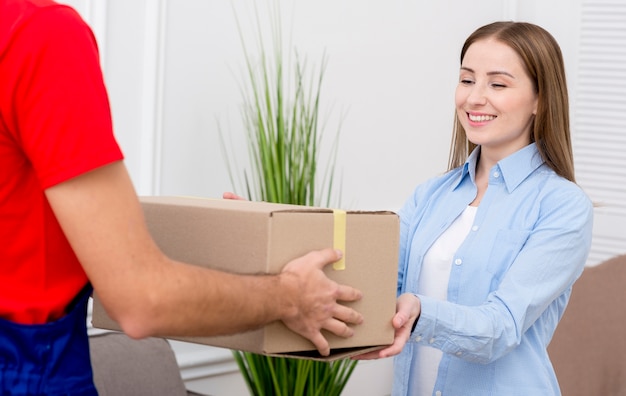 Photo woman receiving a cardboard box from courier