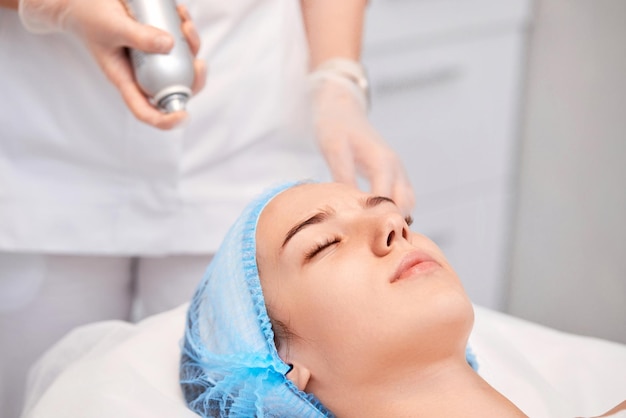 Woman receiving facial massage at spa salon