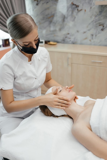 A woman receiving a facial massage in a spa salon