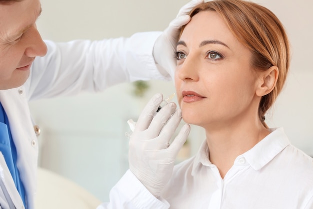 Photo woman receiving filler injection in beauty salon