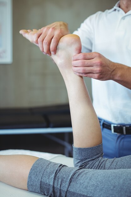 Donna che riceve massaggio ai piedi dal fisioterapista