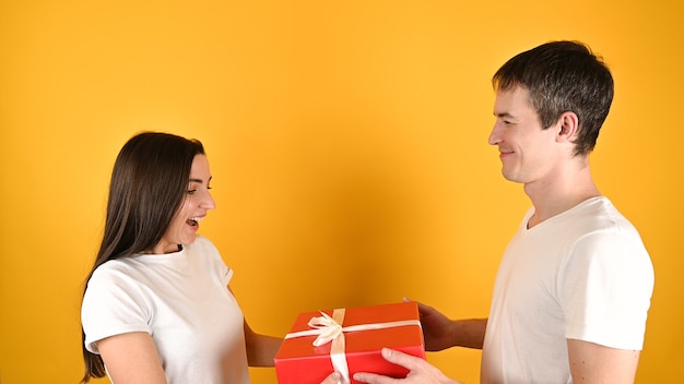 Woman receiving a gift from her lover on yellow