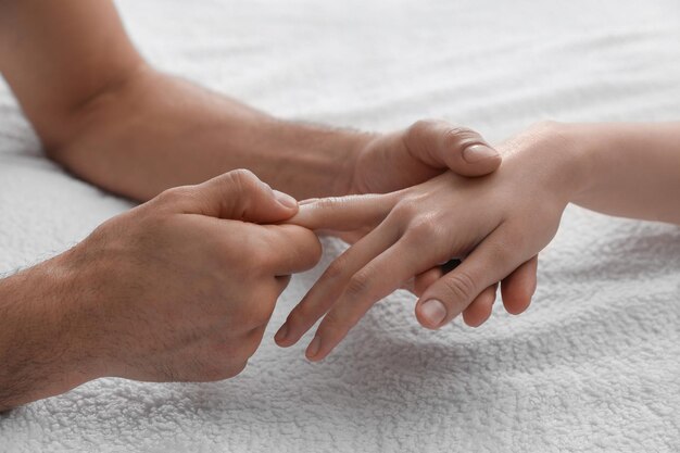 Фото Женщина получает массаж рук на мягком полотенце крупным планом
