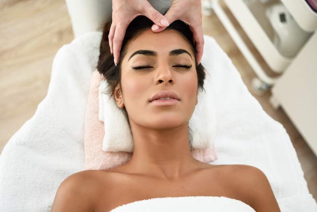 Woman receiving head massage in spa wellness center.