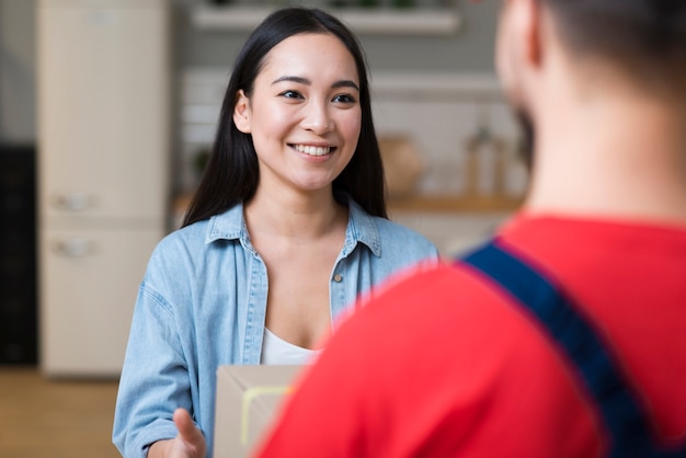 Photo woman receiving her online order from delivery man