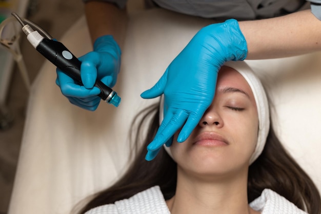 Photo woman receiving hydrafacial treatment in beauty salon