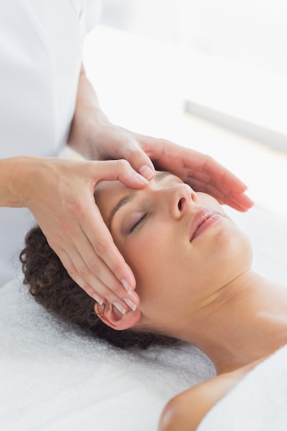 Woman receiving massage on forehead