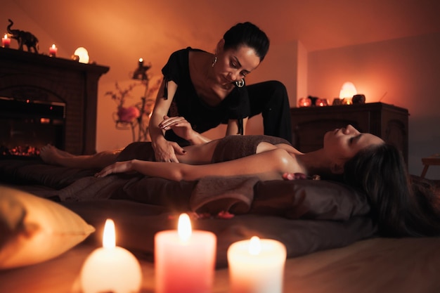 Woman receiving a massage with candles in the background