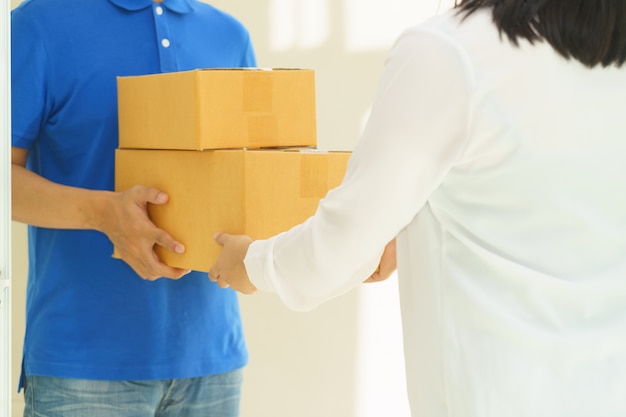 Woman receiving package from delivery man.