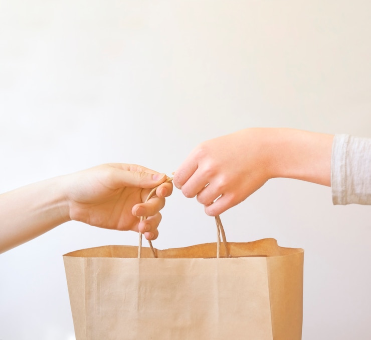 Woman receiving a package at home from a delivery man.
