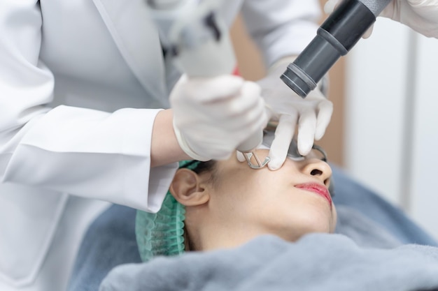 Photo woman receiving pico laser facial treatment in beauty clinic