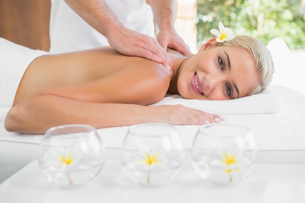 Woman receiving shoulder massage at spa center