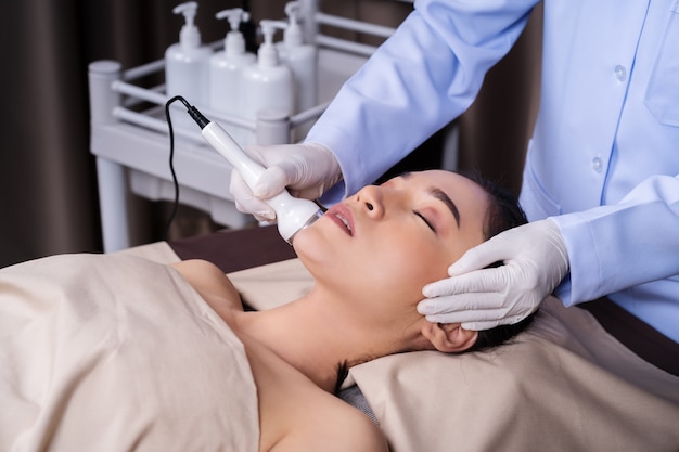 Woman receiving ultrasound facial beauty treatment skin care